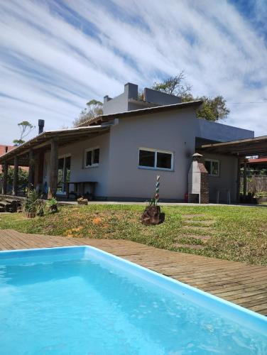 a house with a blue swimming pool in front of it at Chalé Bela Vista in Torres