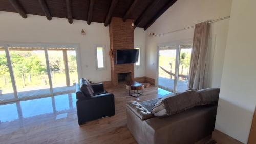 a living room with a couch and a television at Chalé Bela Vista in Torres