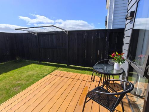 a patio with a table and chairs on a deck at Hideaway in Green Hill Park in Hamilton