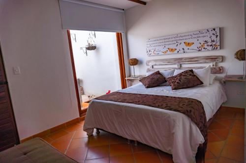 a bedroom with a bed and a large window at Casa Macondo Sachica-Villa de Leyva in Sáchica