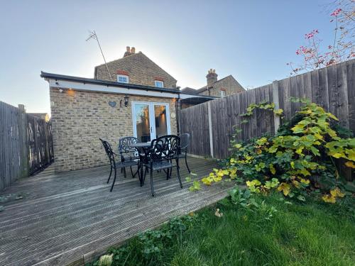 a wooden deck with a table and chairs on it at Studio-4 for professionals in Staines