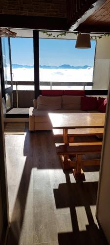 a living room with a couch and a large window at Studio Duplex 8 personnes Vue à couper le souffle in Saint-Honoré