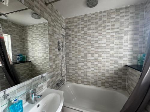 a bathroom with a white tub and a sink at Studio-4 for professionals in Staines