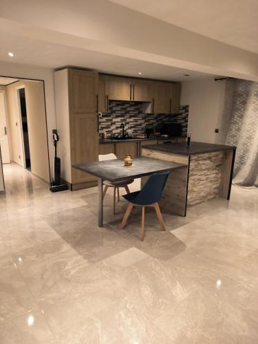 une cuisine avec une table et une chaise dans une pièce dans l'établissement La Villa du Melda 15min de Troyes, à Villacerf