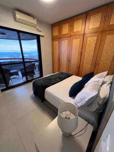 a bedroom with a bed and a large window at Apto frente praia-AlfaPark-Barra da Tijuca in Rio de Janeiro