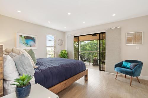 a bedroom with a king sized bed and a blue chair at Beautiful Kawama Townhouse-P6 in Key Largo