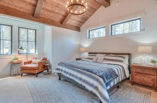 a bedroom with a bed and a chair and windows at Sablerock 1 in Sunriver
