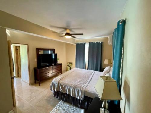 a bedroom with a bed and a flat screen tv at Hibiscus a New Spacious Apartment with a Sea View and Perfect Location in Contant