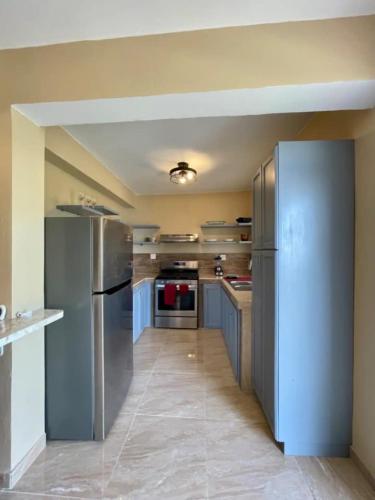 a large kitchen with stainless steel appliances in it at Hibiscus a New Spacious Apartment with a Sea View and Perfect Location in Contant