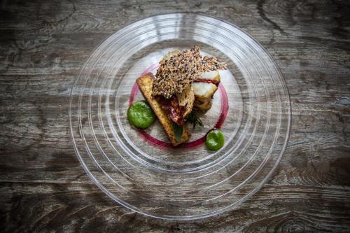 a glass plate with a sandwich and pickles on a table at La Regalido in Fontvieille