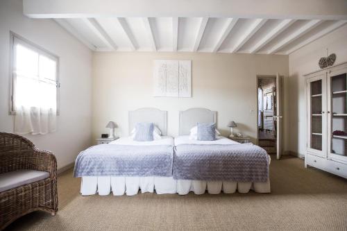 a bedroom with a large white bed with two pillows at La Regalido in Fontvieille