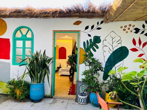 a room with a wall with a door with plants at Art riad au bord de la mer 1 in El Jadida