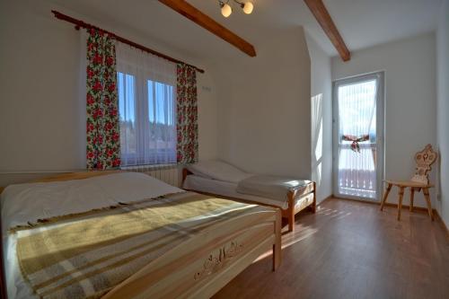 a bedroom with a bed and a large window at Pokoje Gościnne Sztokfisz in Bukowina Tatrzańska