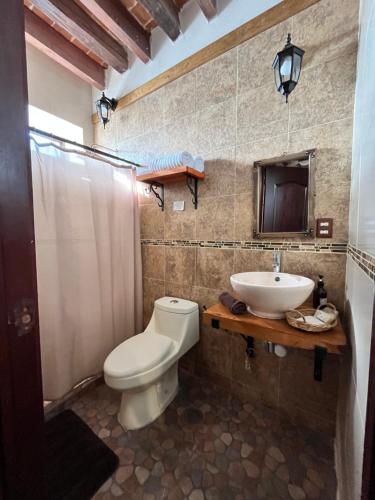 a bathroom with a toilet and a sink at Casa Gardenia Hotel in Tecozautla