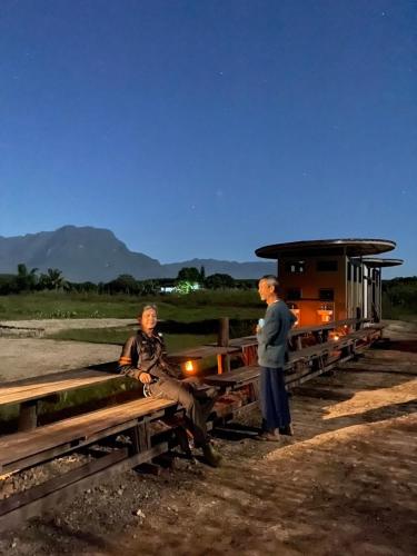 two men are standing next to a train at Daraga ดารกะ in Chiang Dao