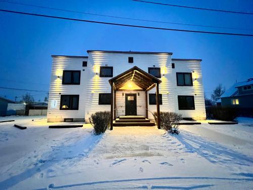 a white house with lights on it in the snow at Dollhouse Downtown in Fairbanks