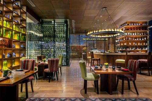 a restaurant with tables and chairs and a bar at The Ritz-Carlton, Bangalore in Bengaluru