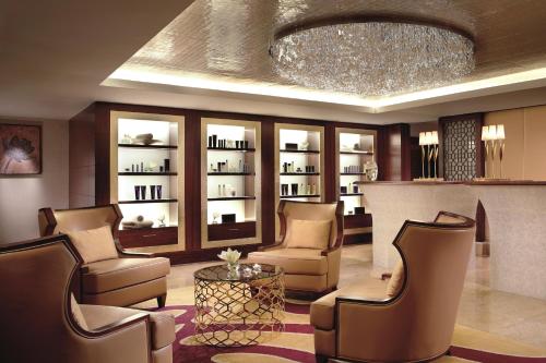 a lobby with chairs and a table and a chandelier at The Ritz-Carlton, Bangalore in Bengaluru