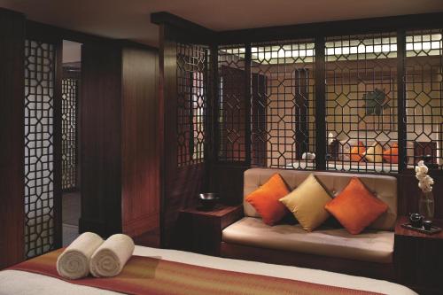 a room with a bed and a couch with pillows at The Ritz-Carlton, Bangalore in Bengaluru