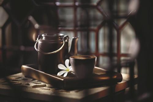 a tea pot and a cup on a table at The Ritz-Carlton, Bangalore in Bengaluru