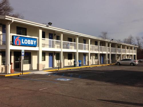 a hotel with a car parked in a parking lot at Motel 6 New Brunswick in New Brunswick