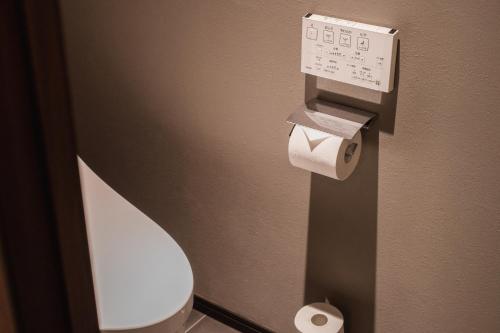 a bathroom with a toilet and two rolls of toilet paper at The LOFT INN HAKATA in Fukuoka
