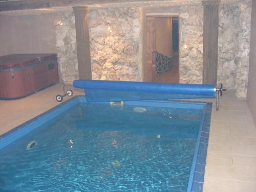 Una gran piscina de agua en una habitación con una pared de piedra. en Drevenica Zuberec, en Zuberec