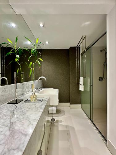a bathroom with a sink and a mirror at Premier Apartment - Hotel Mercure Belém Boulevard in Belém