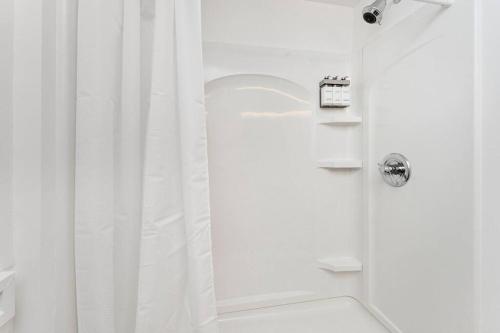 a bathroom with a shower with a white shower curtain at Relaxing 3-Bedroom With 150 Inch Projector & Pool Table in Jacksonville