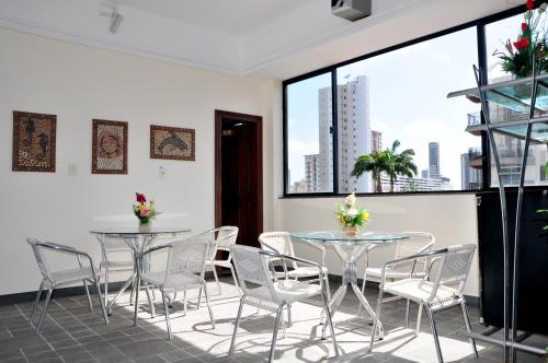 een kamer met 2 tafels en stoelen en een groot raam bij Machado´s Plaza Hotel in Belém