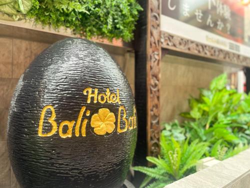 a black vase with a flower painted on it at Hotel BaliBali Matsudo in Matsudo
