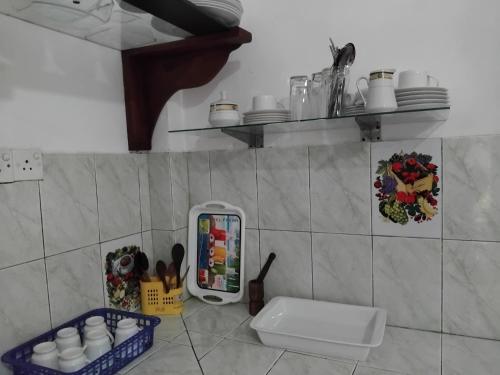 een keuken met een koelkast en planken aan de muur bij Green Villa Home in Anuradhapura