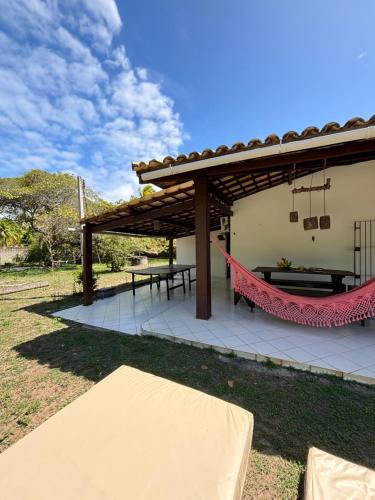 a patio with a hammock under a pergola at Sítio Águas do Éden , pé na areia, frente rio, praia e campo no mesmo lugar in Camaçari