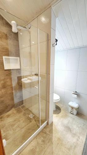 a bathroom with a glass shower and a toilet at Chalé Sunset in Miguel Pereira