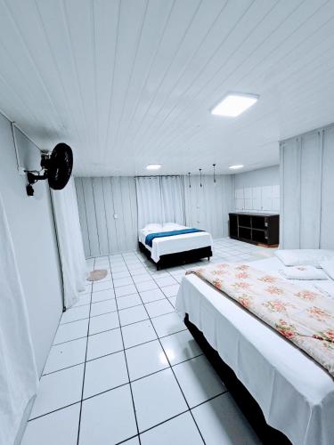 a bedroom with two beds and a camera in it at Cantinho da Nonna in Morretes