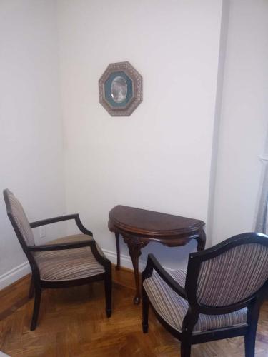 a room with two chairs and a table and a clock at Waterfront Hideaway Private Suite-King bed room in Tottenham