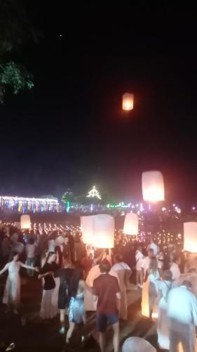 eine große Gruppe von Menschen, die nachts Schilder halten in der Unterkunft Three moon in Doi Saket