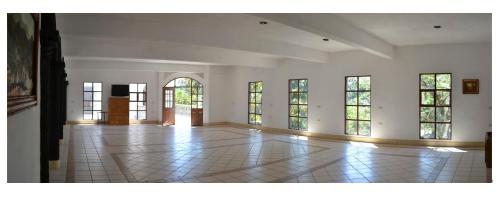 a large room with windows and a tiled floor at Hotel Hacienda Xico Inn in Xico