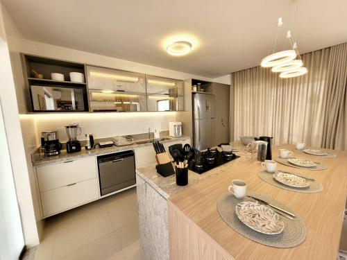 a kitchen with a table with two plates on it at Bangalô Exclusivo A6 Imbassaí Privilege Beira Mar in Imbassai
