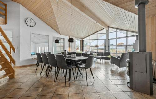 Fjellerup StrandにあるGorgeous Home In Glesborg With Saunaのテーブルと椅子と時計のあるダイニングルーム