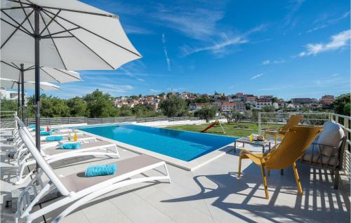 une terrasse avec des chaises, une piscine et un parasol dans l'établissement Beautiful Home In Seget Vranjica, à Seget Vranjica