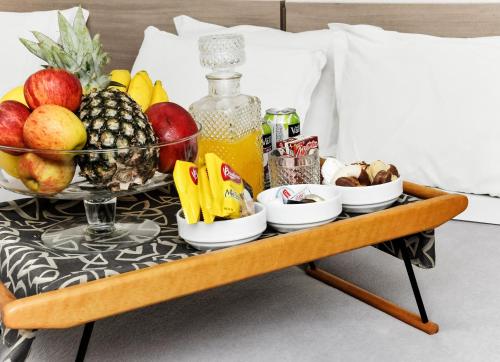 a tray of fruit and juice on a bed at Vivendas Hotel in Erechim