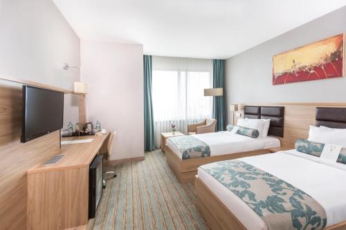 エラズーにあるPark Dedeman Elazığのベッド2台、薄型テレビが備わるホテルルームです。
