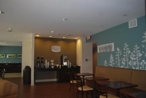 a restaurant with tables and chairs and a bar at Sleep Inn & Suites Clintwood in Clintwood