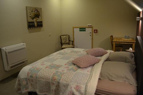 a bedroom with a bed and a table and a chair at B&B Hof Ter Haegen in Vollezele