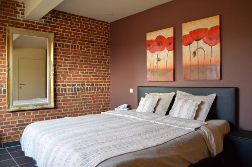 a bedroom with a bed with a brick wall at B&B Hof Ter Haegen in Vollezele