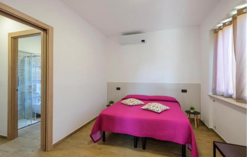a bedroom with a bed with a pink blanket at 2 Bedroom Cozy Apartment In Moscufo in Moscufo