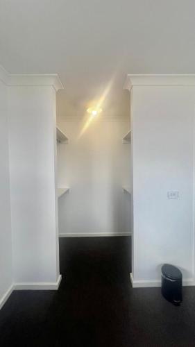 una stanza vuota con pareti bianche e una luce di Room in Melbourne Manor Lakes a Wyndham Vale