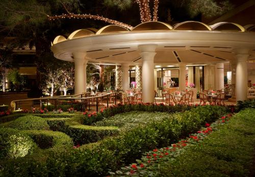 a resort with a garden with flowers and tables and chairs at Encore at Wynn Las Vegas in Las Vegas