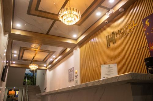 a lobby with two chandeliers and a yellow wall at Hotel Mall plaza in Santa Marta